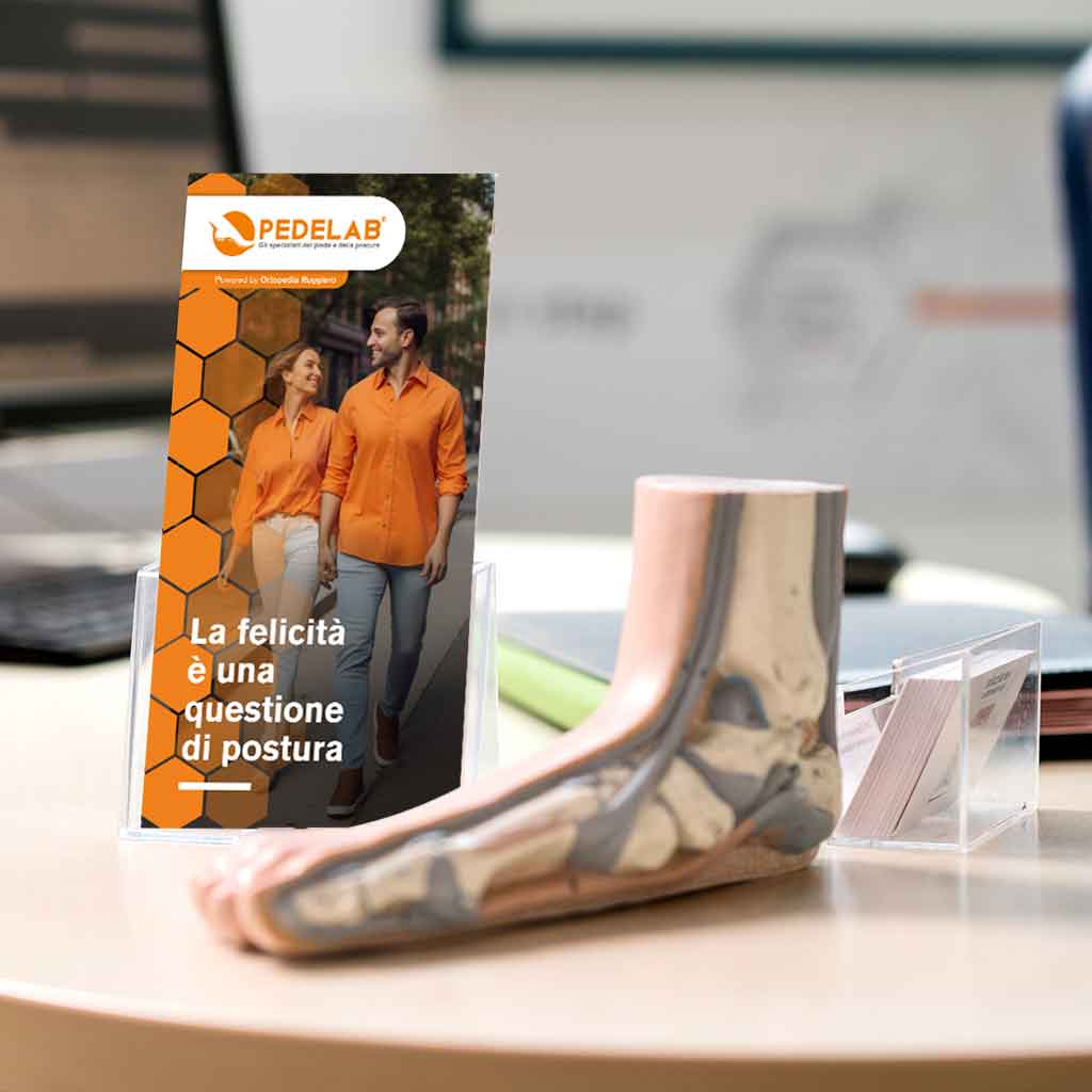 Scrivania in uno studio Pedelab di Ortopedia Ruggiero con brochure e modello di un piede
